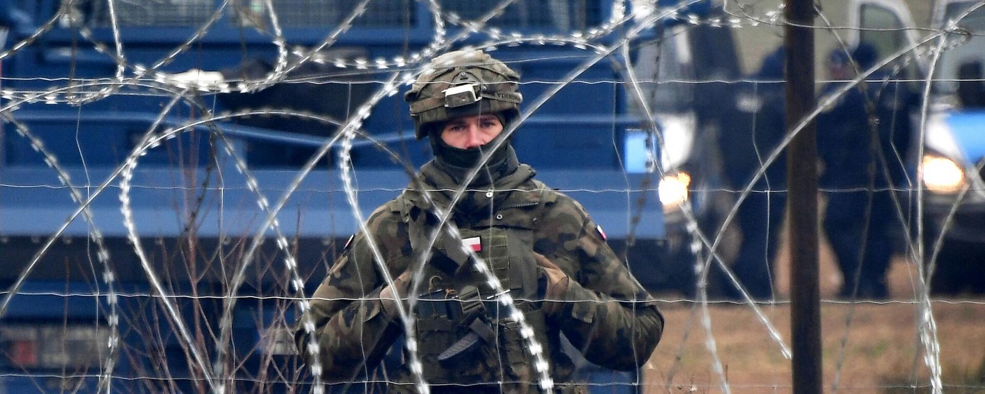 A Polish serviceman stands guard behind a barbed wire on border - Sputnik International, 1920, 03.06.2024