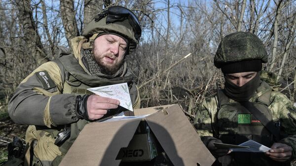 Rostislav Zhuravlev (L) hands letters to Russian fighters in the special operation zone - Sputnik International
