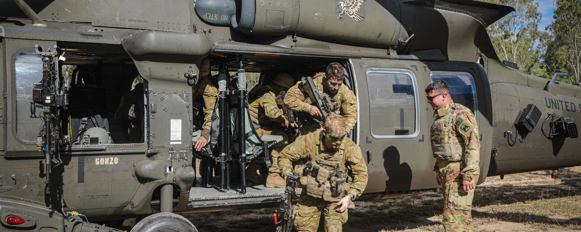 Sgt. Louis Ortiz, 16th Combat Aviation Brigade, Task Force Warhawk, Battle Group Griffin, evaluates Soldiers from the Australian Defence Force (ADF) as they exit an UH-60 Black Hawk assigned to 16th CAB during hot/cold loading training, as a part of Exercise Talisman saber in an ADF training area outside of Townsville, Queensland, Australia, July 22, 2023. - Sputnik International, 1920, 24.07.2023