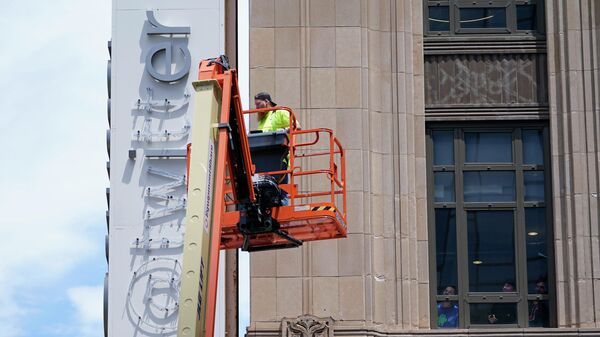 Workers inside Twitter headquarters watch from a window as a workman removes signage on Monday, July 24, 2023, in in San Francisco.  (AP Photo/Godofredo A. Vásquez) - Sputnik International