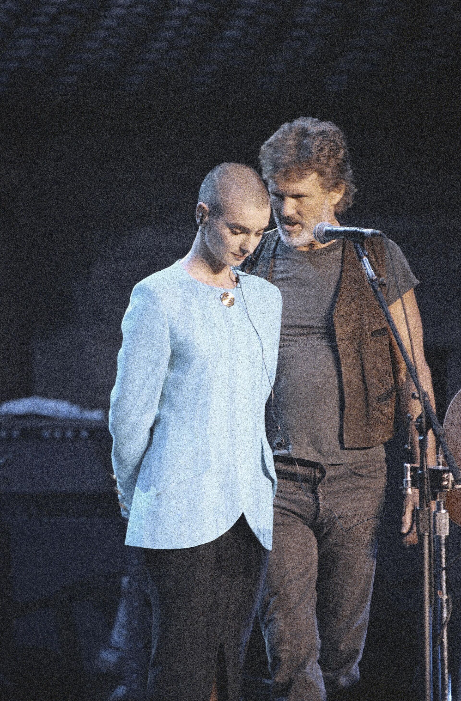 FILE - Kris Kristofferson comforts Sinead O'Connor after she was booed off stage during the Bob Dylan anniversary concert at New York Madison Square Garden, on Oct. 17, 1992. The performance was O'Connor's first live event since she ripped a picture of Pope John Paul II during a performance on Saturday Night Live. O’Connor, the gifted Irish singer-songwriter who became a superstar in her mid-20s but was known as much for her private struggles and provocative actions as for her fierce and expressive music, has died at 56. The singer's family issued a statement reported Wednesday by the BBC and RTE. - Sputnik International, 1920, 26.07.2023