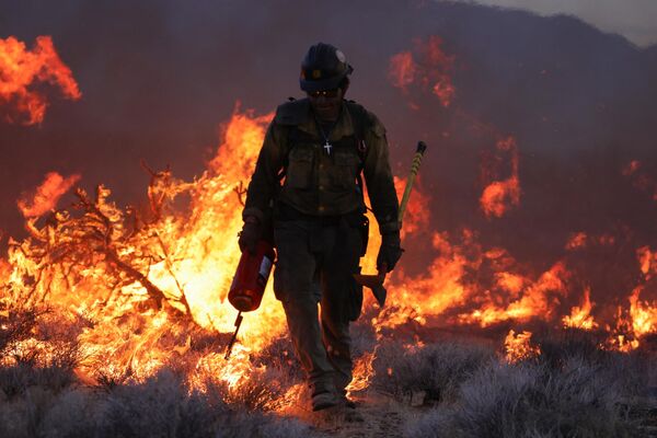 A firefighter battling the York Fire in the Mojave National Preserve on July 30, 2023. - Sputnik International