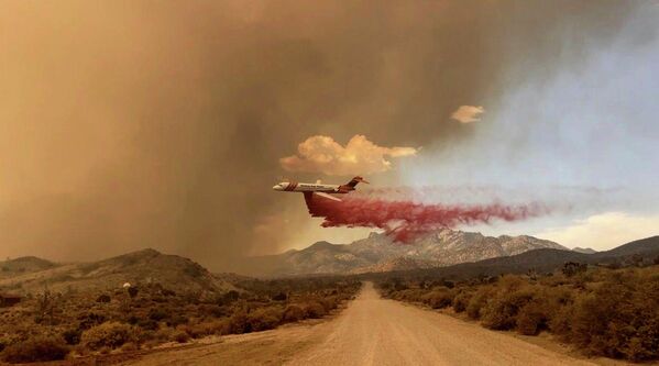 An aircraft drops fire retardant over the York Fire in the Mojave National Preserve on July 29, 2023. - Sputnik International