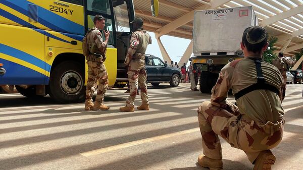 French soldiers assist mostly French nationals in a bus waiting to be airlifted back to France on a French military aircraft, at the international Airport in Niamey, Niger, Tuesday, Aug. 1, 2023. The French Foreign Ministry in Paris cited recent violence that targeted the French Embassy as one of the reasons for the evacuation. The decision comes during a deepening crisis sparked by the coup last week against Niger's democratically elected president, Mohamed Bazoum.  - Sputnik International