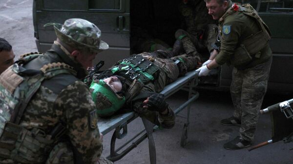 Ukrainian military medics carry a wounded Ukrainian serviceman delivered from a front line position to a stabilization point.  - Sputnik International