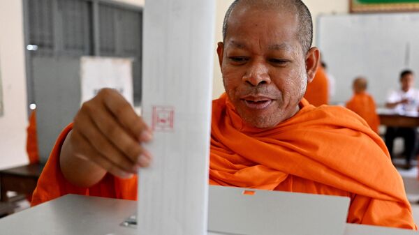 A Buddhist monk casts his vote at a polling station in Phnom Penh on July 23, 2023 during the general elections. (Photo by TANG CHHIN Sothy / AFP) - Sputnik International
