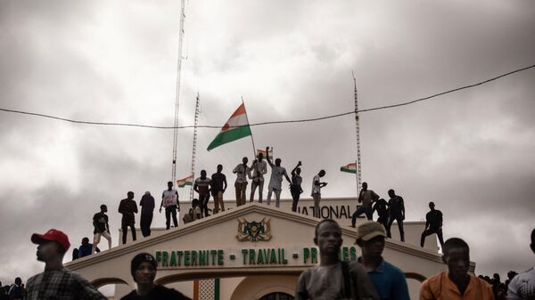 Protesters hold a Niger flag during a demonstration on independence day in Niamey on August 3, 2023. Hundreds of people backing the coup in Niger gathered on August 3, 2023 for a mass rally in the capital Niamey with some brandishing giant Russian flags. - Sputnik International