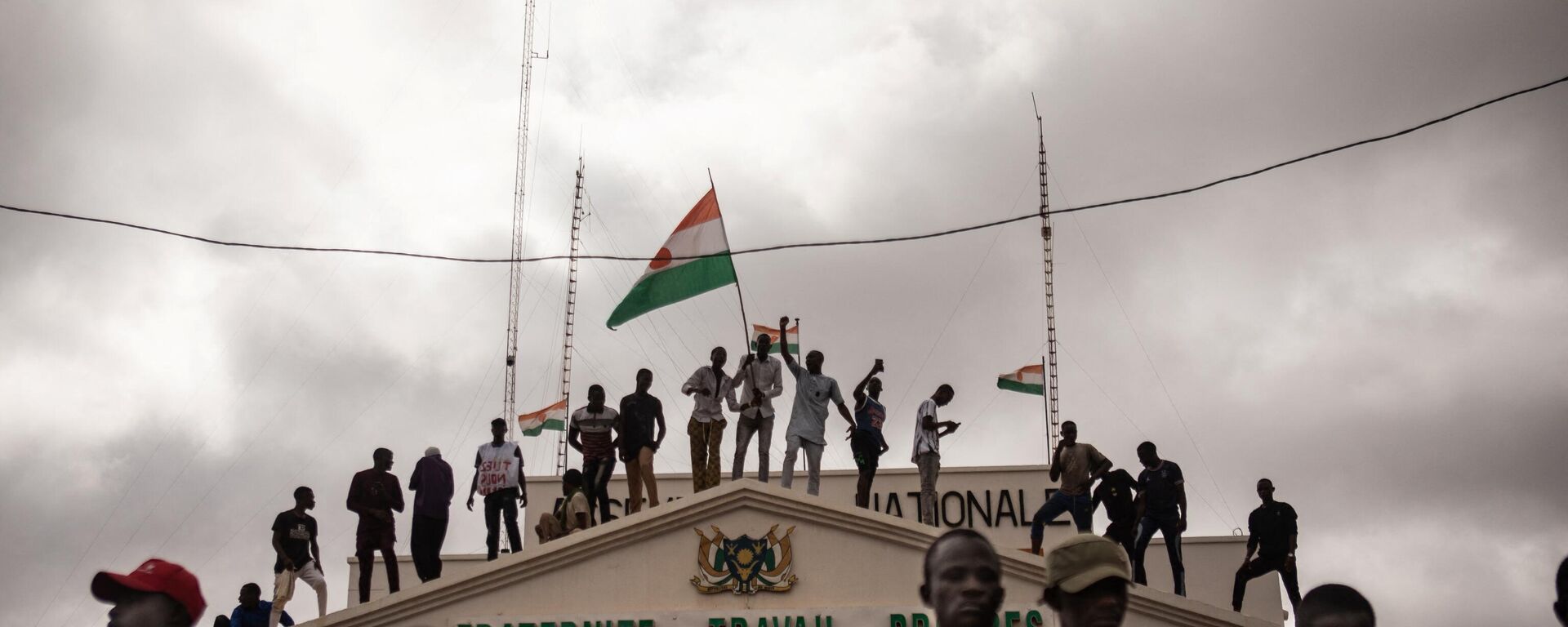 Protesters hold a Niger flag during a demonstration on independence day in Niamey on August 3, 2023. Hundreds of people backing the coup in Niger gathered on August 3, 2023 for a mass rally in the capital Niamey with some brandishing giant Russian flags. - Sputnik International, 1920, 14.08.2023