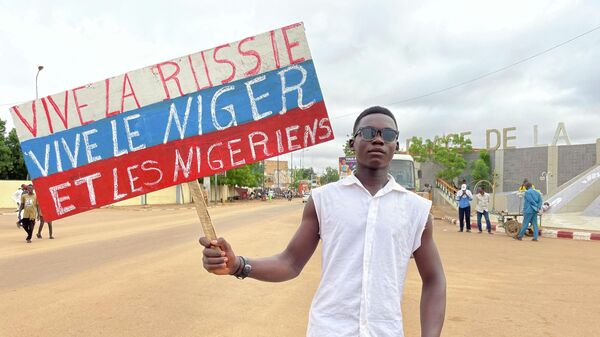 A Nigerien man holds a placard reading Long Live Russia, Long Live Niger and Nigeriens in the capital Niamey - Sputnik International