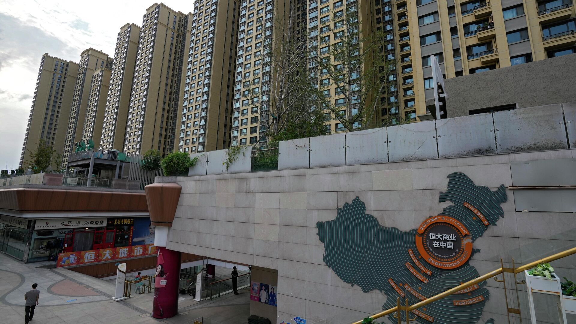A man walks by a China's map showing Evergrande development projects and its apartment buildings are seen behind, at an Evergrande city plaza in Beijing. File photo. - Sputnik International, 1920, 29.01.2024