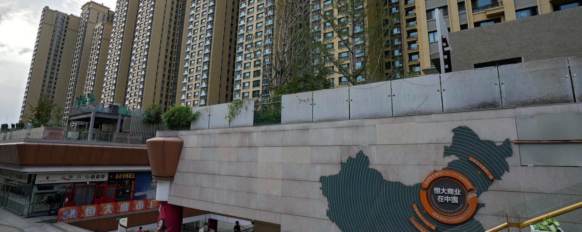 A man walks by a China's map showing Evergrande development projects and its apartment buildings are seen behind, at an Evergrande city plaza in Beijing. File photo. - Sputnik International, 1920, 29.01.2024