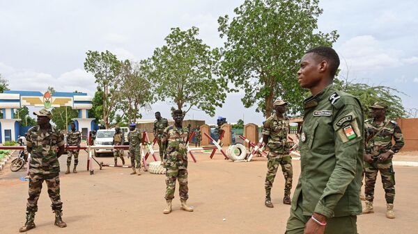 Nigerien soldiers stand guard as supporters of Niger's National Council for the Safeguard of the Homeland (CNSP) gather for a demonstration in Niamey on August 11, 2023 near a French airbase in Niger - Sputnik International