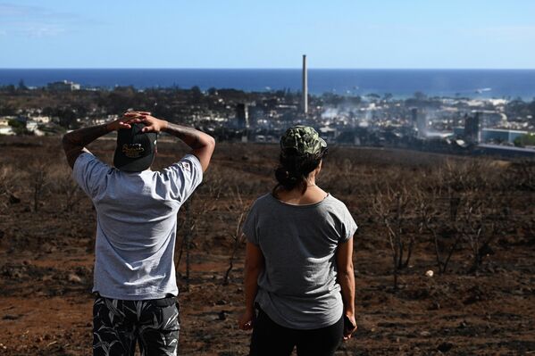 Maui residents look from a road above Lahaina Town, devastated by an inferno.  - Sputnik International
