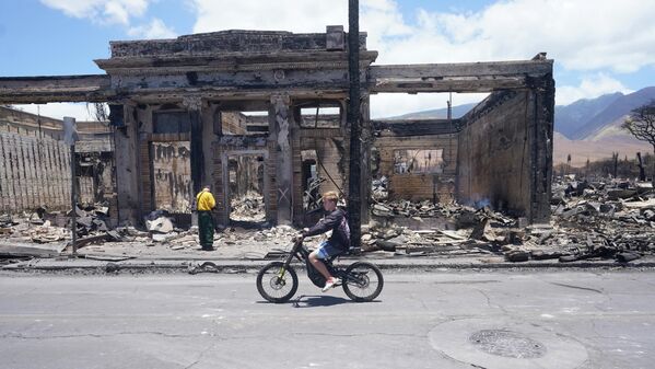 A boy rides along a main street in wildfire-hit Lahaina. - Sputnik International
