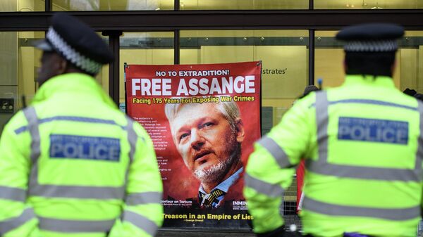 A police officer stands in front of the banner with a photo of Julian Assange near the Westminster Magistrates' Court in London - Sputnik International