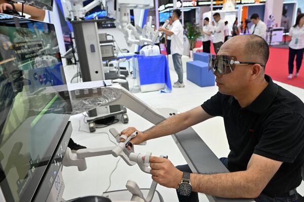 A man examines a robotic arm used for surgery. - Sputnik International