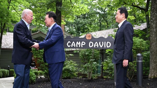 US President Joe Biden (L) welcomes South Korean President Yoon Suk Yeol (C) and Japanese Prime Minister Fumio Kishida to Camp David, Maryland, for a Trilateral Summit on August 18, 2023. - Sputnik International