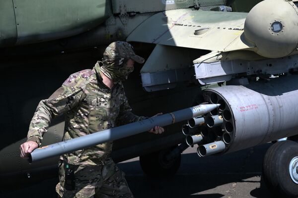 A Mi-28 attack helicopter is loaded up with unguided missiles before a sortie in the special op zone. - Sputnik International