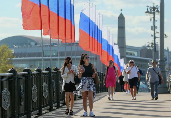Pedestrians on the Borodinsky Bridge in Moscow, where Russian flags were installed to mark Russian National Flag Day. - Sputnik International