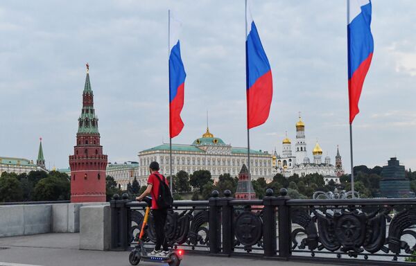 A boy rides an electric scooter on the Greater Stone Bridge in Moscow. The Kremlin is in the background. - Sputnik International