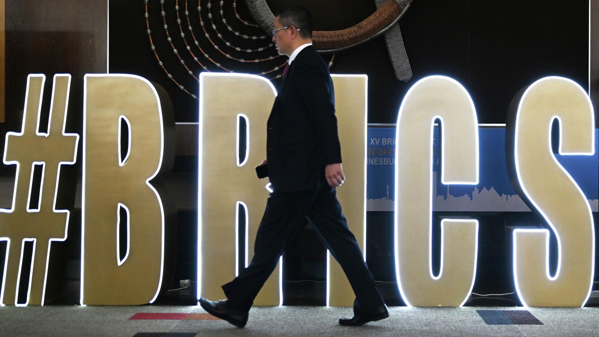 A participant strolls past a huge BRICS hashtag at the bloc's 15th summit in South Africa on August 22, 2023. - Sputnik International, 1920, 23.08.2023