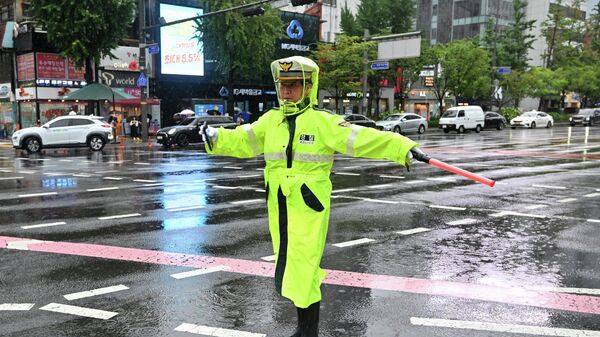 A police officer controls traffic on an empty street during a civil defence drill against possible artillery attacks by North Korea in Seoul on August 23, 2023 - Sputnik International