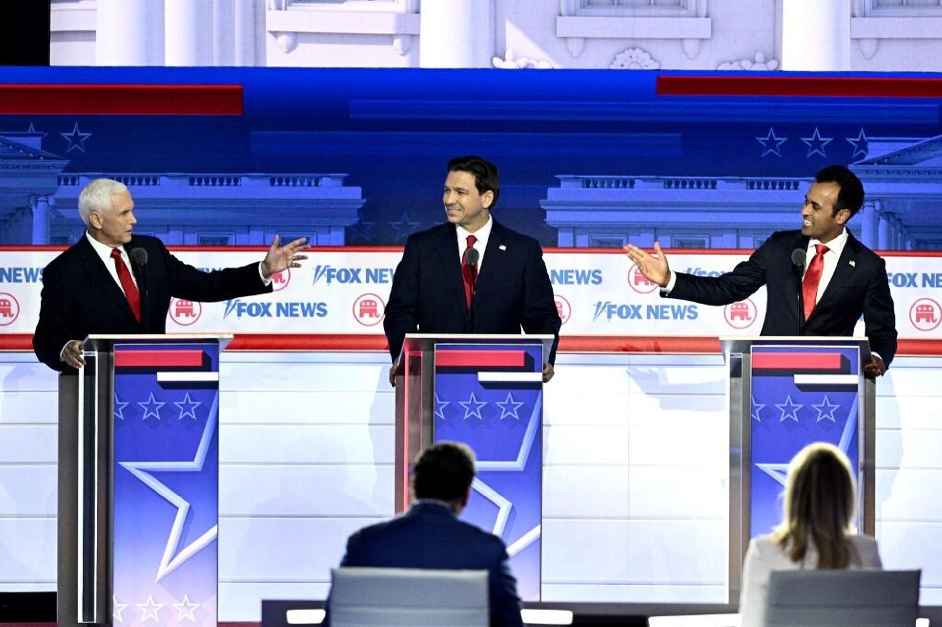 Former US Vice President Mike Pence (L) and entrepreneur and author Vivek Ramaswamy (R) gesture toward Florida Governor Ron DeSantis during the first Republican Presidential primary debate at the Fiserv Forum in Milwaukee, Wisconsin, on August 23, 2023. - Sputnik International, 1920, 24.08.2023