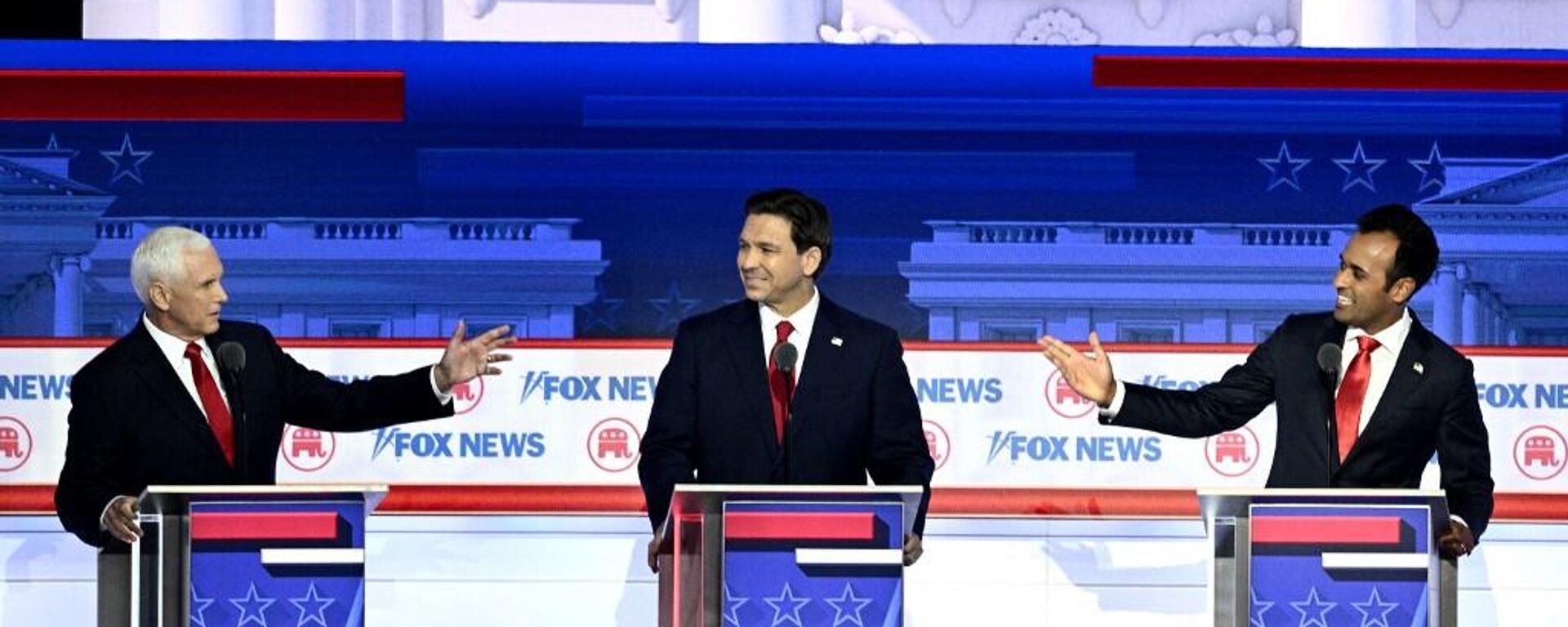 Former US Vice President Mike Pence (L) and entrepreneur and author Vivek Ramaswamy (R) gesture toward Florida Governor Ron DeSantis during the first Republican Presidential primary debate at the Fiserv Forum in Milwaukee, Wisconsin, on August 23, 2023. - Sputnik International, 1920, 25.08.2023