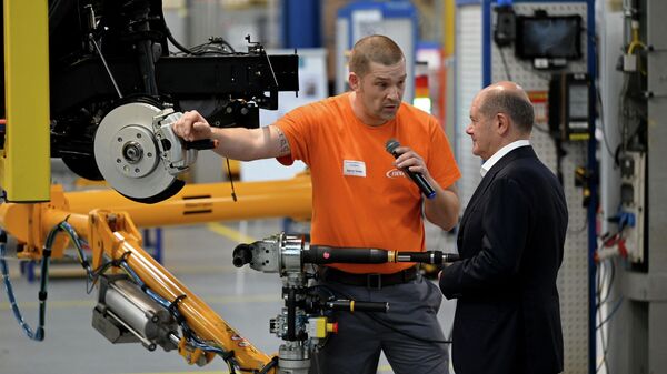 German Chancellor Olaf Scholz (R) talks with an employee who works on the assembling of a brake caliper for an electric vehicle during a visit at the plant of Neapco Europe in Duren, western Germany, on August 22, 2023. - Sputnik International