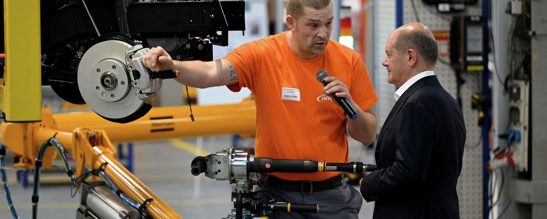 German Chancellor Olaf Scholz (R) talks with an employee who works on the assembling of a brake caliper for an electric vehicle during a visit at the plant of Neapco Europe in Duren, western Germany, on August 22, 2023. - Sputnik International, 1920, 25.08.2023
