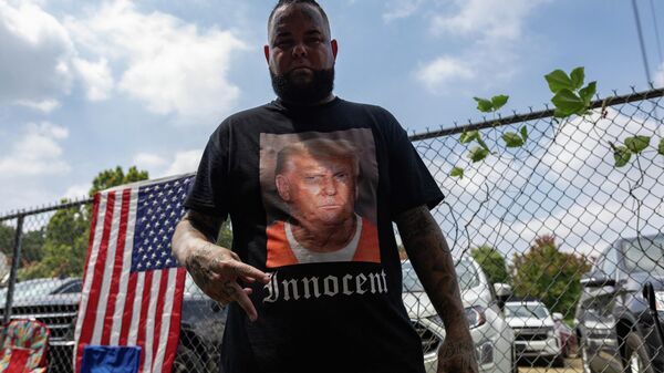 A supporter of former President Donald Trump wears a shirt proclaiming his innocence while waiting for him to arrive outside the Fulton County Jail on August 24, 2023, in Atlanta, Georgia. - Sputnik International