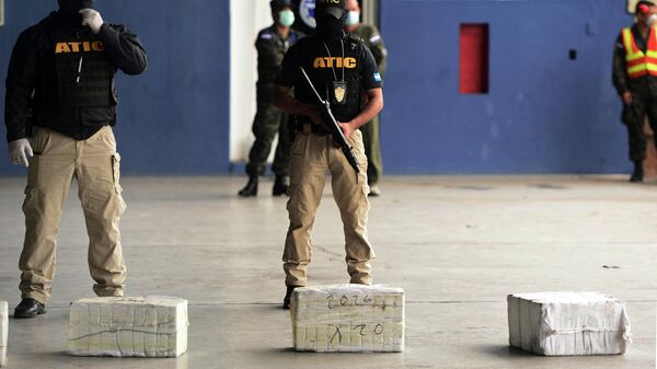 Members of Honduras' Technical Bureau for Criminal Investigation (ATIC) guard packages of cocaine seized from an aircraft found in an illegal landing strip near Brus Laguna in the Caribbean La Mosquitia region, at the Hernan Acosta Mejia air base in Tegucigalpa, on September 25, 2020. - Sputnik International