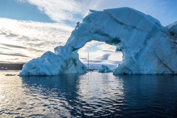 An iceberg and the yacht Alter Ego off the coast of an island in the Franz Josef Land archipelago. - Sputnik International