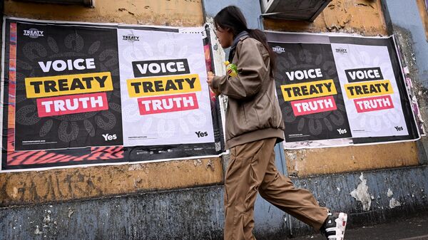 A woman walks past posters advocating for an Aboriginal voice and treaty ahead of an upcoming referendum, in Melbourne on August 30, 2023 - Sputnik International
