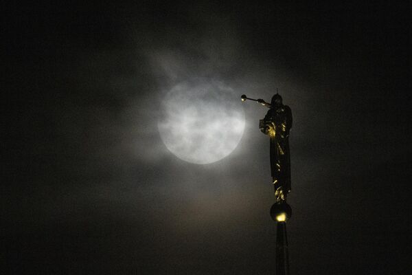 The Supermoon rises behind a thick layer of clouds near a statue of the angel Moroni perched atop The Church of Jesus Christ of Latter-day Saints, in Kensington, Md., the US, Wednesday, Aug. 30, 2023,  - Sputnik International