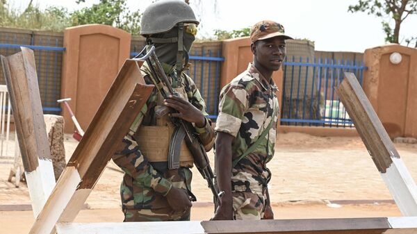 Nigerien soldiers stand guard as supporters of Niger's National Council of Safeguard of the Homeland (CNSP) protest outside the Niger and French airbase in Niamey on August 30, 2023 to demand the departure of the French army from Niger. - Sputnik International