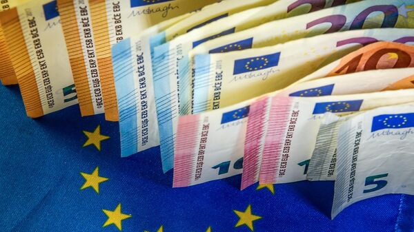Euro banknotes are displayed next to an European Union flag. - Sputnik International