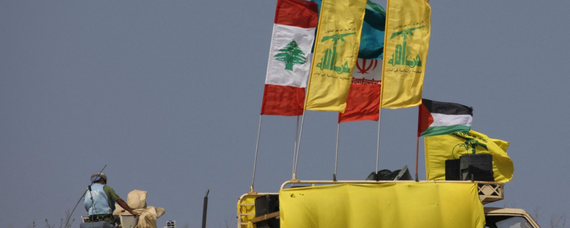 A picture taken on May 20, 2021, from the northern Israeli town of Metula near the border with Lebanon, people raising Palestinian, Lebanese and Iran-backed Hezbollah flags during a rally in solidarity with the Palestinians, on the outskirts of the southern Lebanese village of Kfarkila, near a United Nations Interim Force in Lebanon (UNIFIL) armoured personnel carrier. - Sputnik International, 1920, 02.09.2023