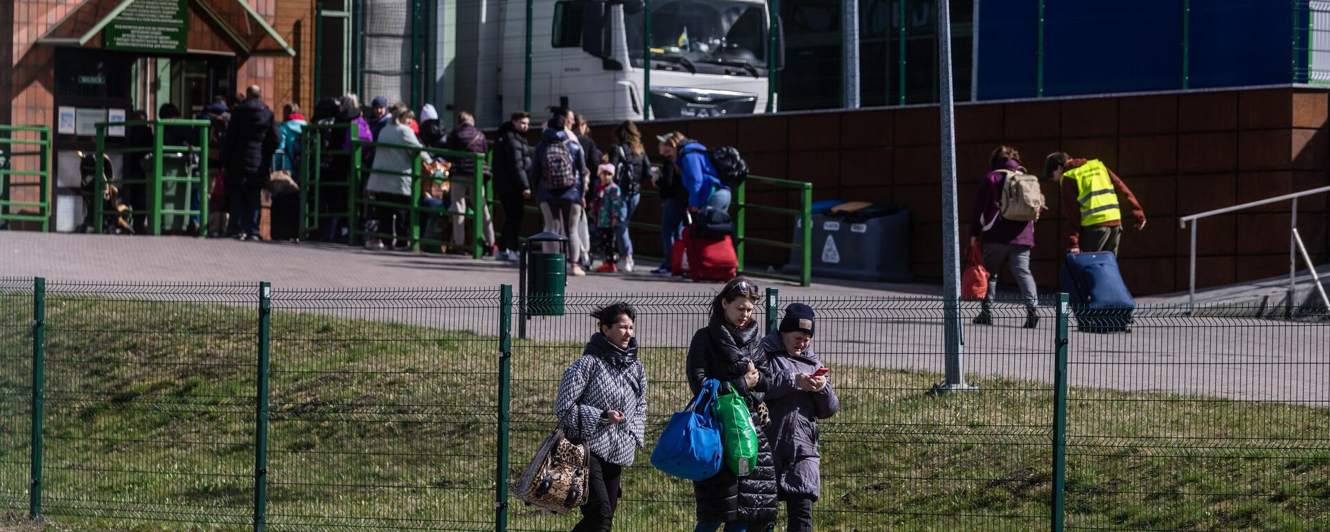 People queue to cross the border on their way back to Ukraine (back) as refugees from Ukraine are seen arriving in Poland (front) at the border crossing in Medyka, southeastern Poland on April 8, 2022. - Sputnik International, 1920, 02.09.2023