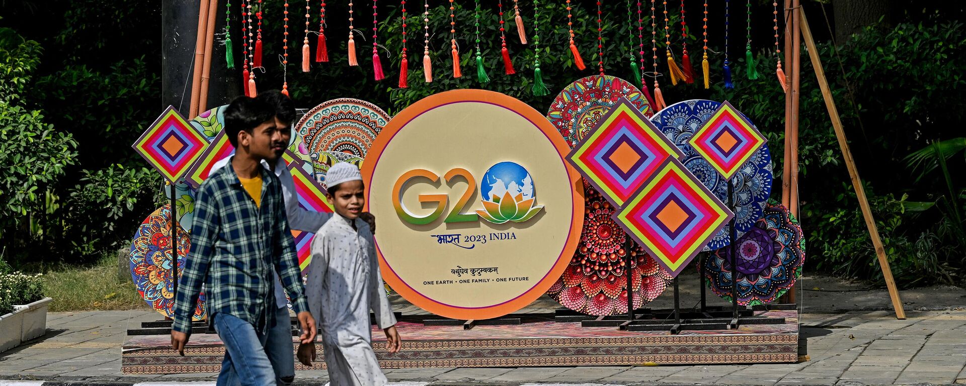 Pedestrians walk next to a G20 India summit logo ahead of its commencement in New Delhi on September 3, 2023.  - Sputnik International, 1920, 09.09.2023