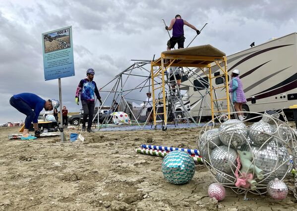 Attendees of the annual Burning Man festival in Nevada’s Black Rock desert, known as &quot;burners,&quot; strike down their Unicorner camp before new rainfalls on September 3, 2023. (Photo by Julie JAMMOT / AFP) - Sputnik International