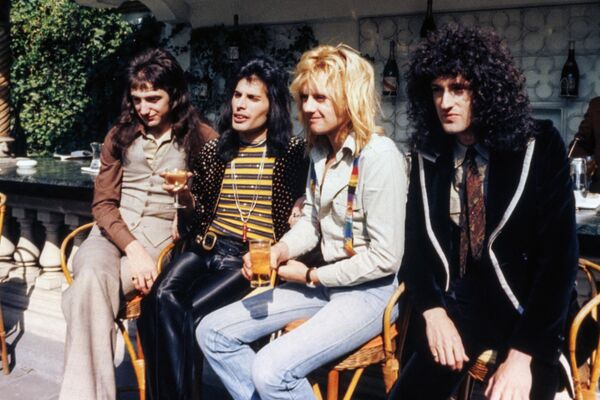 After moving to England, Freddie Mercury teamed up with musicians from the rock band called Smile. He insisted on rebranding it to Queen. Pictured in the photo above: John Deacon, Freddie Mercury, Roger Taylor, and Brian May pose after receiving a British Phonographic Institute Platinum, Gold and Silver award for record sales in London on September 8, 1976. - Sputnik International