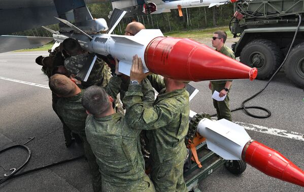 Soldiers load projectiles on a Su-30 fighter jet. - Sputnik International