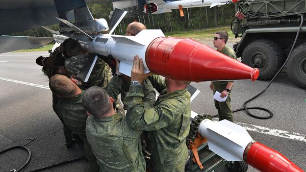 Soldiers load projectiles on Su-30 fighter jet.  - Sputnik International