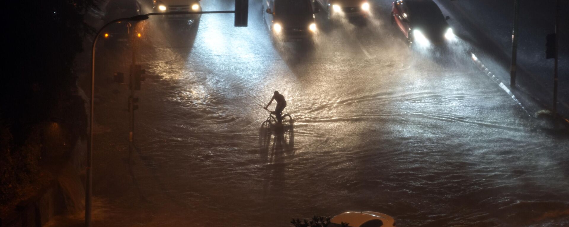 A cyclist rides through floodwater blocking the road due to heavy rain in Basaksehir district of Istanbul, Turkiye, Tuesday, Sept. 5, 2023. Flash floods triggered by heavy rains swept through a campsite in northwest Turkiye on Tuesday, killing at least two people, officials said. Four other people were reported missing.  - Sputnik International, 1920, 06.09.2023