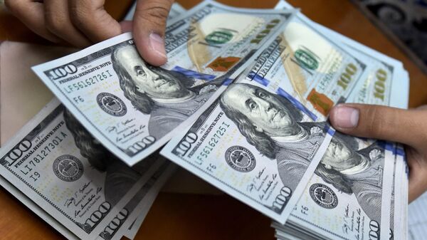 A money changer counts US dollar banknotes for customers. - Sputnik International