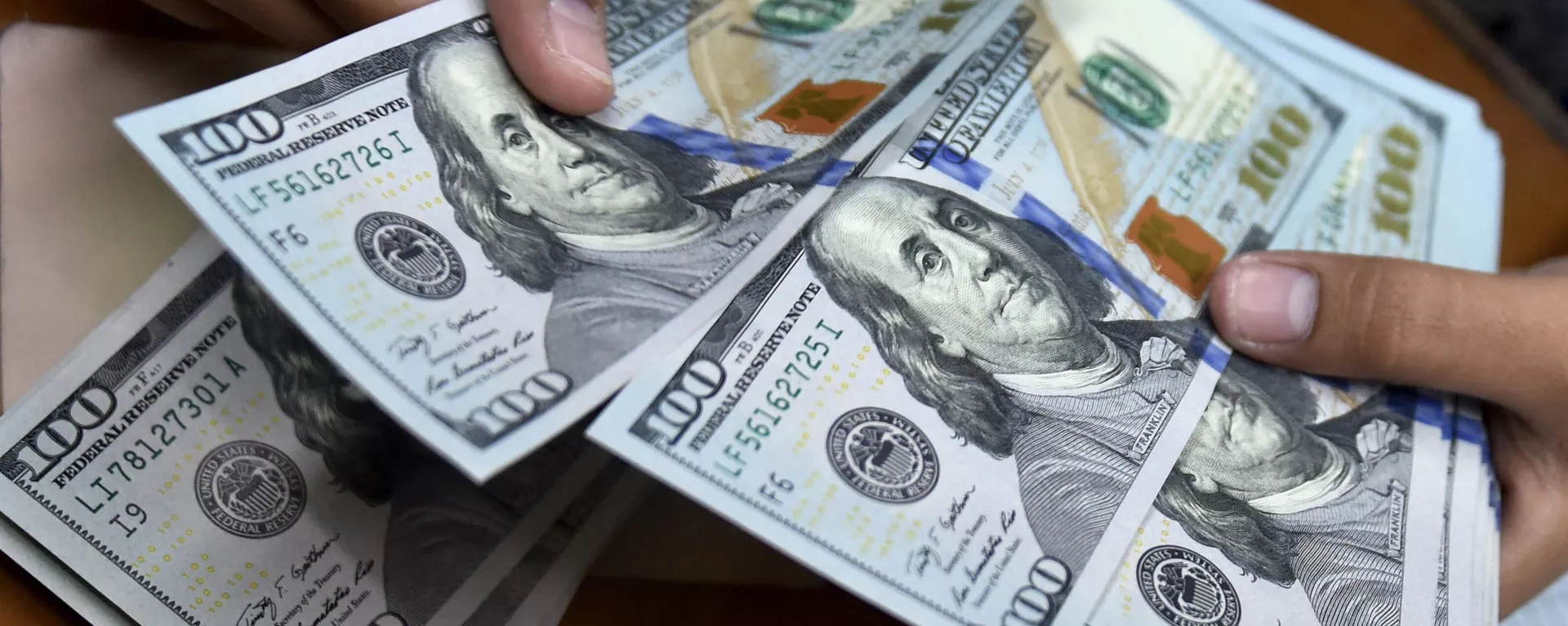A money changer counts US dollar banknotes for customers. A money changer counts US dollar banknotes for customers. - Sputnik International, 1920, 10.09.2023