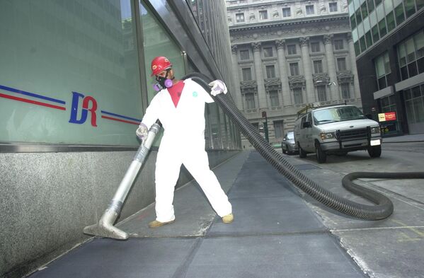 A worker vacuums up debris in downtown Manhattan on 15 September 2001. - Sputnik International