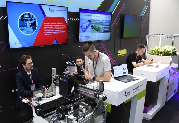 A group of people who take part in the EEF present technological breakthroughs at a stand. - Sputnik International