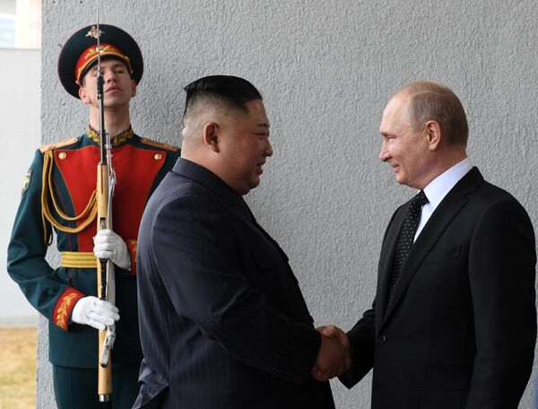 Vladimir Putin and Kim Jong-un during the official meeting ceremony in front of the main entrance of one of the buildings of the Far Eastern Federal University on Russky Island. - Sputnik International